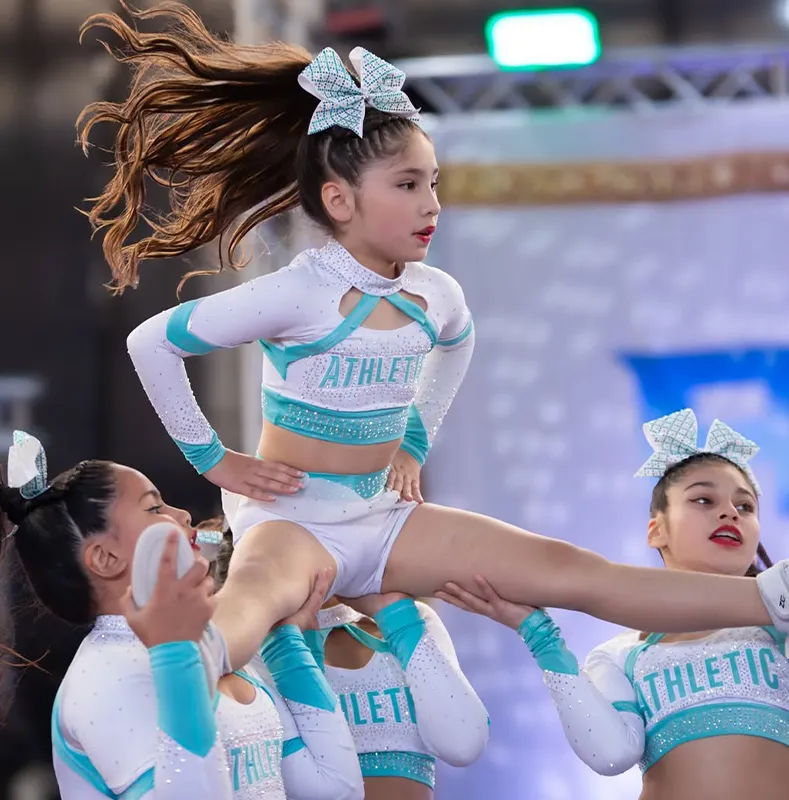 Flyer in a custom rhinestone cheer uniform during a stunt